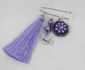 Paarse vriendschapsbroche met pompon 