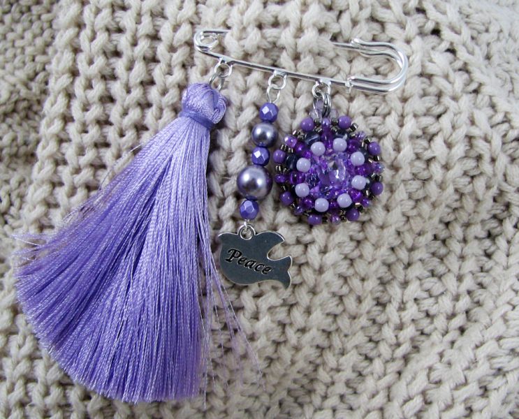 Paarse vriendschapsbroche met pompon 